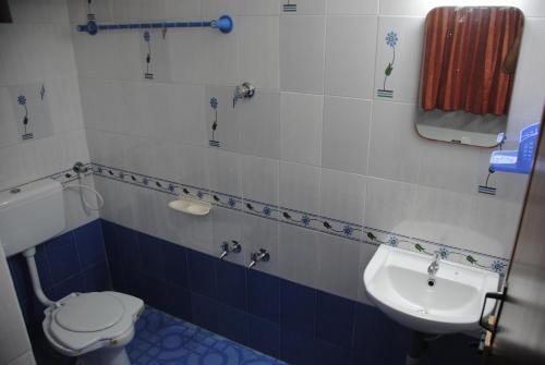 a bathroom with a toilet and a sink at CBR Ayurhealth in Kannur