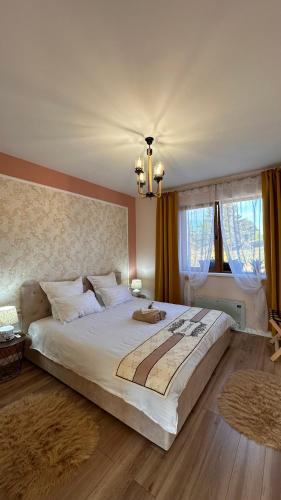 a bedroom with a large white bed with a chandelier at Cozy Living in Dealu Negru