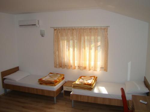 two beds in a room with a window at Pansion Ivan in Međugorje