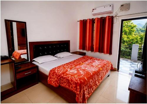 a bedroom with a bed and a window with red curtains at cp residency in Karnaprayāg