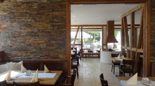 un restaurante con mesas y sillas y una pared de ladrillo en Alte Schmiede en Großbottwar