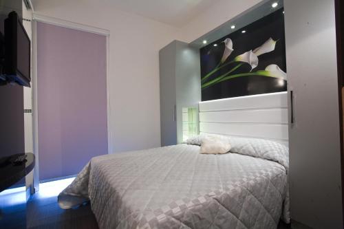 a bedroom with a bed with a flower painting on the wall at Hotel Villa Paola in Rimini