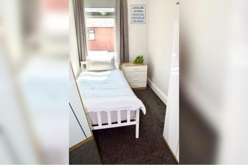 a small room with a mirror and a bed at Spacious 2 Bed Flat - 5 mins to St Helens Centre - Free Parking in Saint Helens