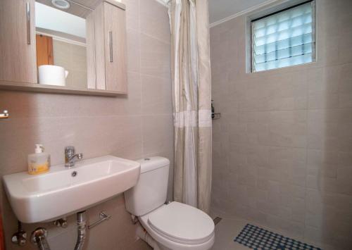 a bathroom with a toilet and a sink and a mirror at Kastraki Villas in Nafplio