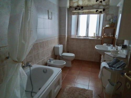 a bathroom with a tub and a toilet and a sink at L'ora d'aria in Bardi