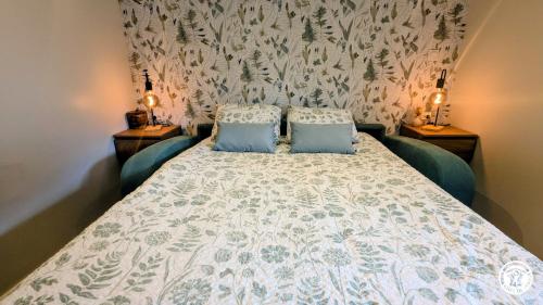a bedroom with a large bed with two blue pillows at Le Tandem in Losne