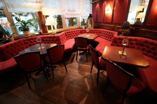 a restaurant with red couches and tables and chairs at Hotel Modena in Bad Steben