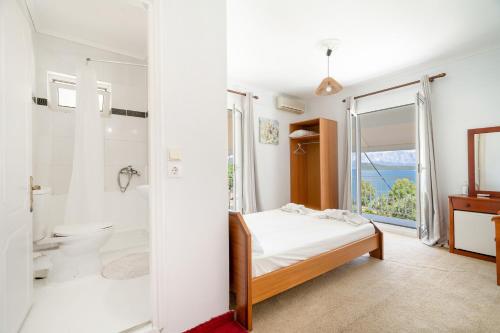 a bedroom with a bed and a bathroom with a shower at Xenia & Antonis in Nikiana