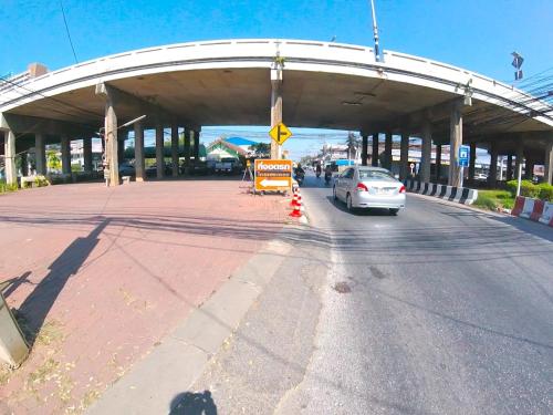 a car driving down a road under a bridge at Kraisaeng Place in Phitsanulok