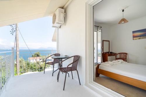 a bedroom with a balcony with a bed and a table at Xenia & Antonis in Nikiana