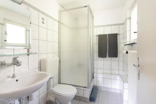 a bathroom with a toilet and a sink and a shower at Mont Gele Hotel in Verbier