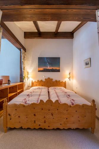 a bedroom with a wooden bed in a room at Chesa La Furia in Pontresina