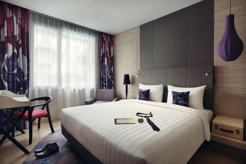 a hotel room with a large bed with a sword on it at Mercure Jakarta Sabang in Jakarta