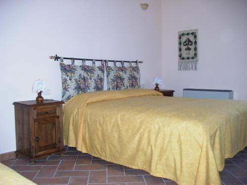 a bedroom with a bed with a yellow bedspread at Agriturismo Radicata in Capalbio