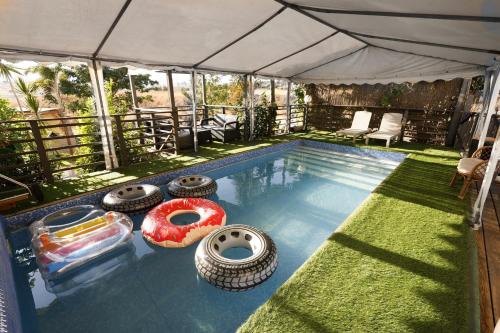 a swimming pool with severallatable tires around it at Iinfinity home in Had Nes