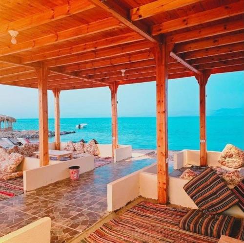 an outdoor pavilion with the ocean in the background at Moon Dune Camp in Nuweiba