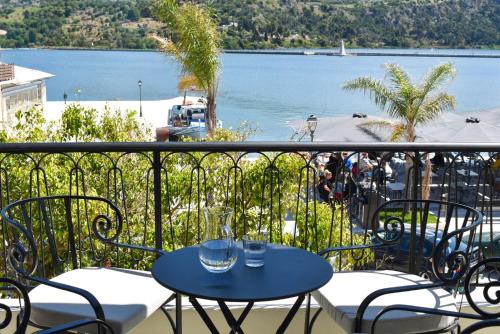 a table and chairs on a balcony with a view of the water at Lanu Apartments in Argostoli