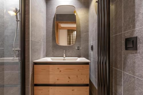 a bathroom with a sink and a mirror at Barma Résidence & Appartements in Courchevel