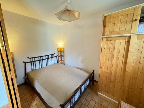 a bedroom with a bed and a wooden door at Les Crêtes studio divisible by Mountain Collection Immobilier in Le Monêtier-les-Bains