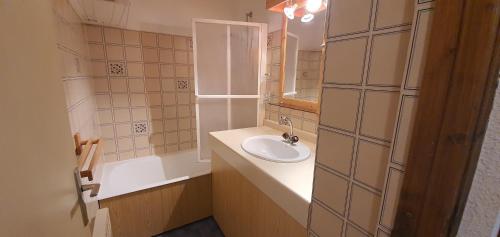 a bathroom with a sink and a mirror and a tub at Les Crêtes studio divisible by Mountain Collection Immobilier in Le Monêtier-les-Bains