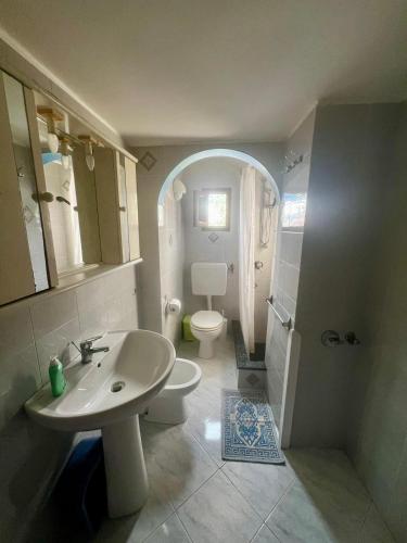 a white bathroom with a sink and a toilet at Holiday Home Case Blu in Lipari