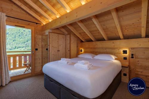 a large bed in a room with a large window at Cozy Chalet with Terrace Peaceful Nature Views in Bluffy