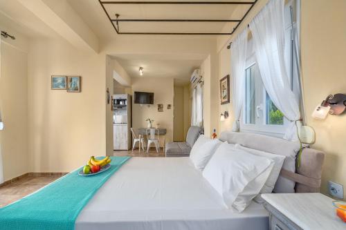 a large white bed in a room with a couch at Kalokairi Boutique Residence in Skopelos Town