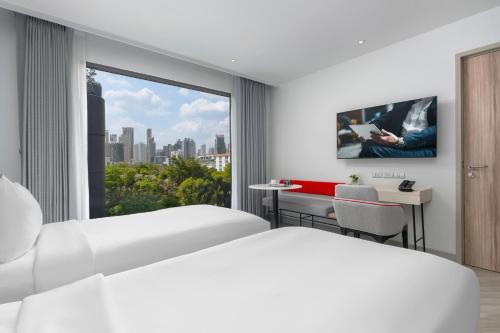 a hotel room with a view of a city at Oakwood Studios Sukhumvit Bangkok in Bangkok