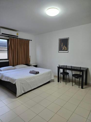 a bedroom with a bed and a desk in it at The Royal Pattaya Cantina Near Walking Steer in Pattaya South