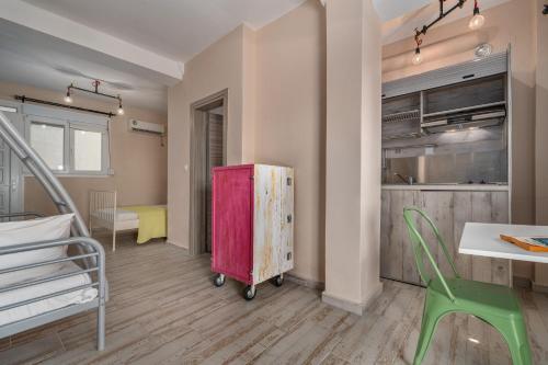 a room with a bed and a kitchen and a table at Kalokairi Boutique Residence in Skopelos Town