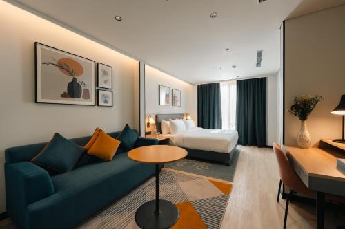 a living room with a blue couch and a bed at Orchid Parc Bengaluru - Manyata Business Park in Bangalore