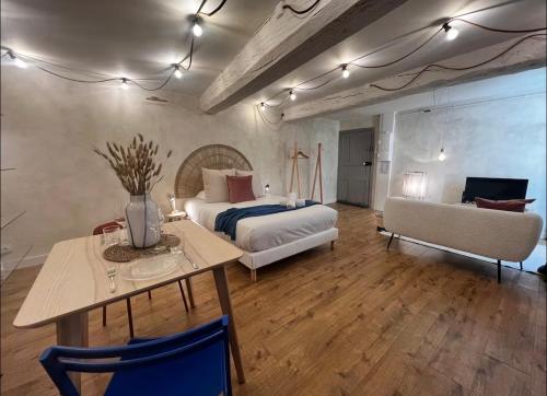 a bedroom with a bed and a table and a couch at Le Petit Horloge, Hyper centre de Rennes in Rennes