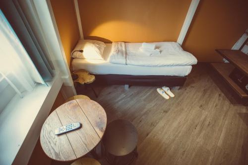 a small room with a small bed and a table at Tourist Inn One Amsterdam in Amsterdam