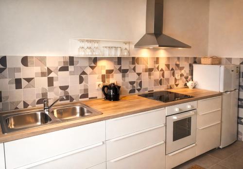 a kitchen with a sink and a refrigerator at Rab Pandelo Apartmani in Rab