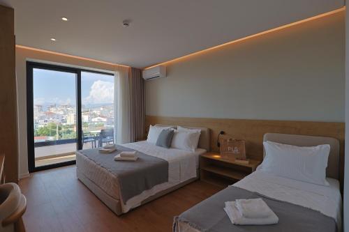 a hotel room with two beds and a large window at Hotel Danedi in Ksamil