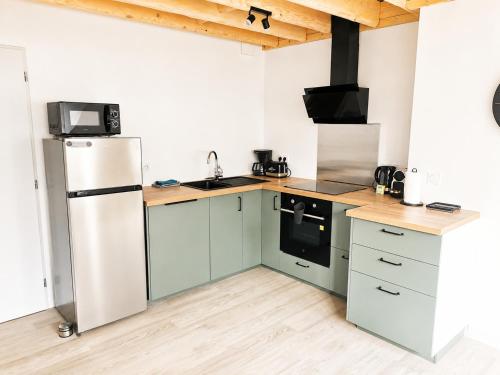 a kitchen with a refrigerator and a sink at Duplex de charme au coeur de Beaugency in Beaugency