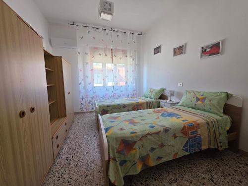 a bedroom with two beds and a window at Casa Bonaria in Terralba