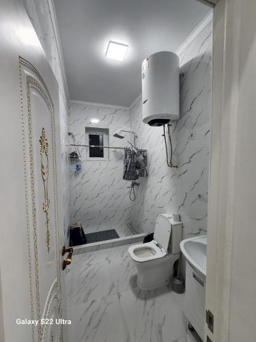 a white bathroom with a toilet and a sink at Коттедж в Sunny Beach in Chok-Tal