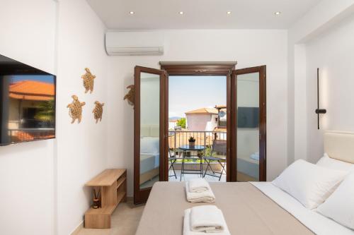 a bedroom with a bed and a balcony at Kallisti Luxury Rooms in Ierissos