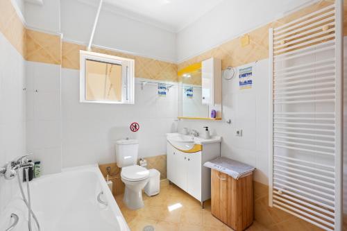 a bathroom with a tub and a toilet and a sink at VALERIA Apartment in Vonitsa