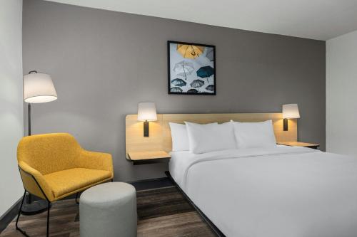 a hotel room with a bed and a chair at City Express by Marriott Yulee in Yulee