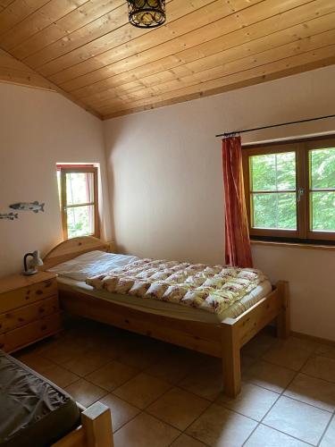 a bedroom with a bed and a wooden ceiling at Seehaus Simssee in Stephanskirchen