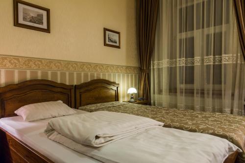 a bedroom with a large bed with white sheets at Hotel Staromiejski in Krasnystaw