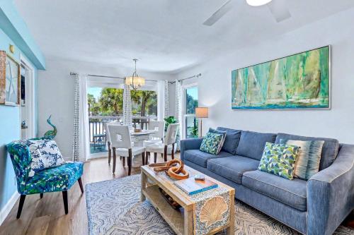 a living room with a blue couch and a table at Gulf Strand Resort 207 in St. Pete Beach