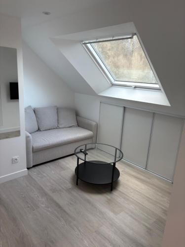 a living room with a couch and a skylight at Sur les toits de Beaugency in Beaugency