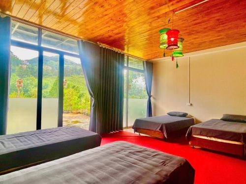 a bedroom with two beds and a large window at Elephant homestay in Sapa