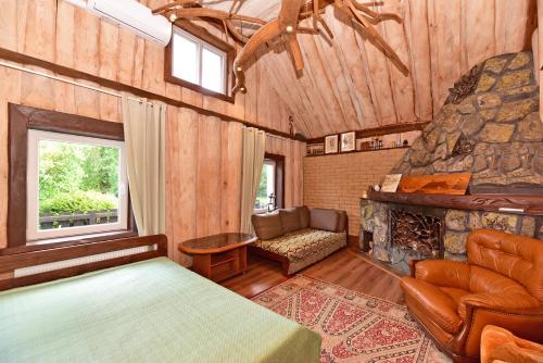 a bedroom with a bed and a stone fireplace at 4gilės sodyba Alytaus rajone in Kružiūnai