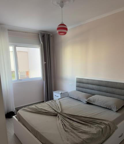 a large bed in a bedroom with a window at Shengjin Paradise Apartment in Shëngjin