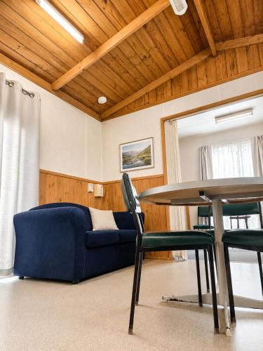 a living room with a blue couch and a table at Shady Acres Caravan Park in Warrenheip