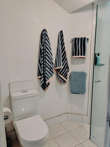 a bathroom with a toilet and towels on the wall at Slow Haus Tanunda in Tanunda